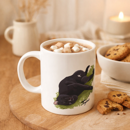Mug personnalisé en céramique de 325 mL avec une illustration de chat, posé sur un bureau à la décoration moderne et épurée. Le mug contient un chocolat chaud garni de guimauves, avec des biscuits à côté, dans une ambiance chaleureuse illustrant l’usage quotidien du mug personnalisé avec illustration animalière.